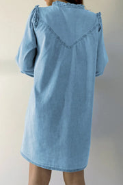 Light blue denim shirt dress with ruffled yoke and V-stitch detail.