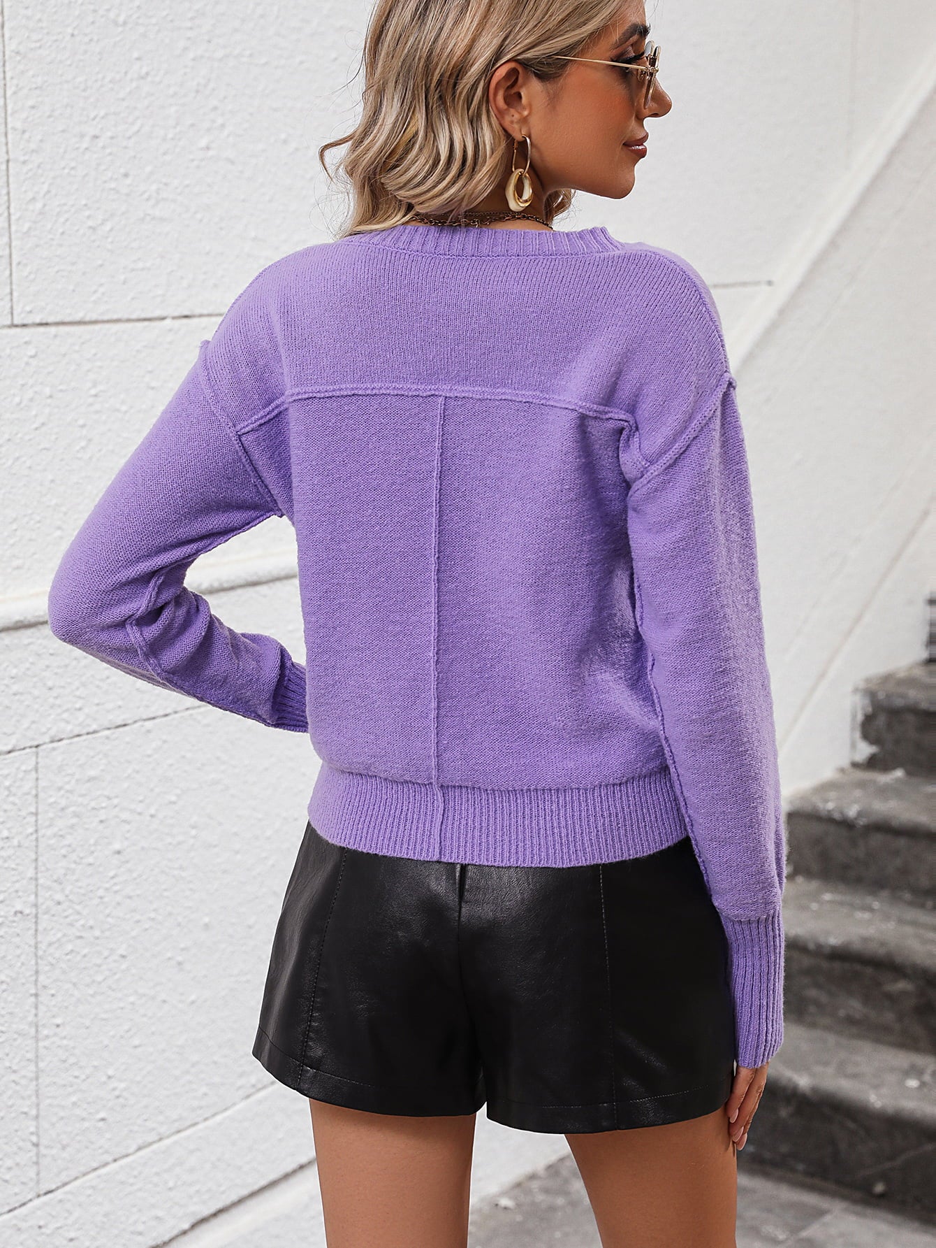 Lavender V-neck knit sweater with relaxed fit and seam detail on back.