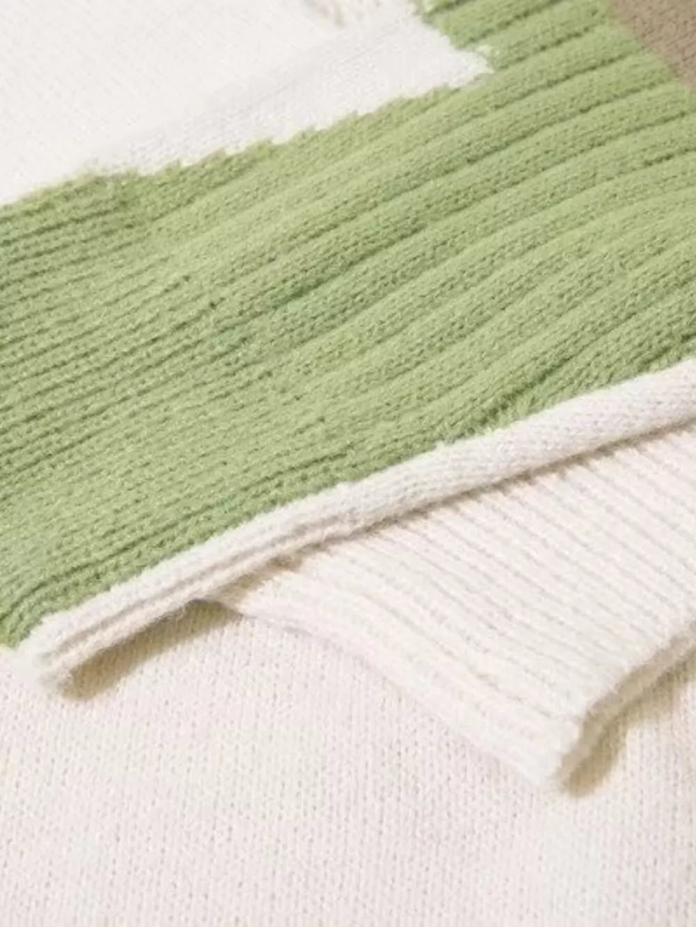 Contrast knit sweater in green and white with textured details and abstract color blocking.