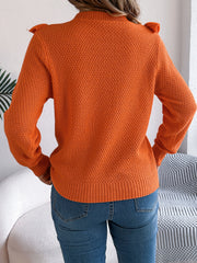 Orange textured knit sweater with ruffle yoke detail and crew neck.
