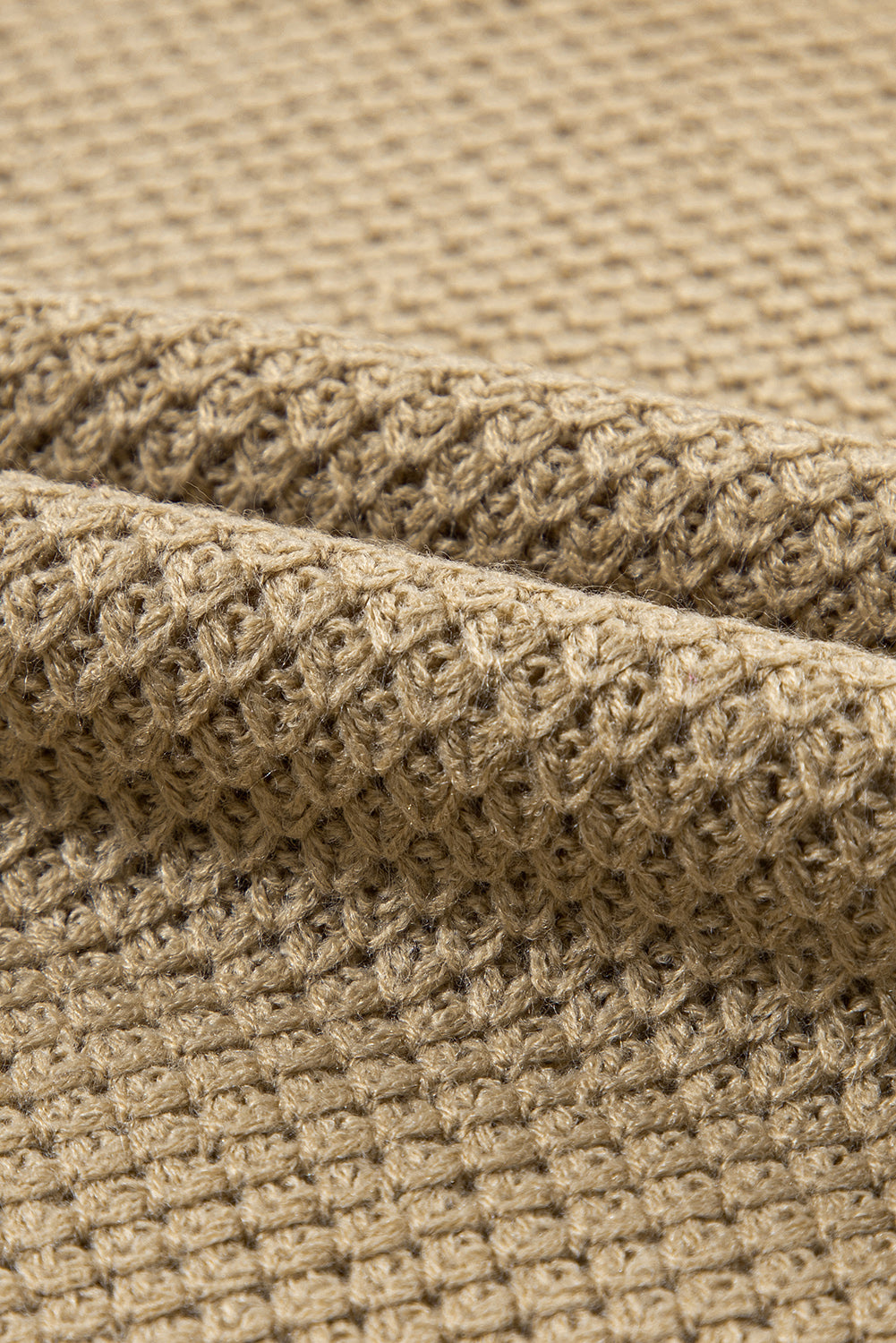 Khaki textured knit turtleneck sweater with cap sleeves and a waffle knit pattern.