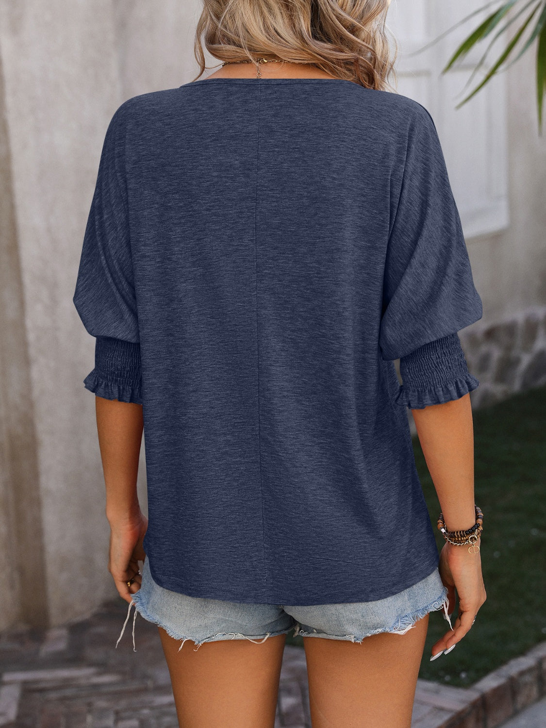 Navy blue blouse with shirred sleeve cuffs and a keyhole neckline detail.