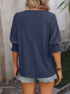 Navy blue blouse with shirred sleeve cuffs and a keyhole neckline detail.