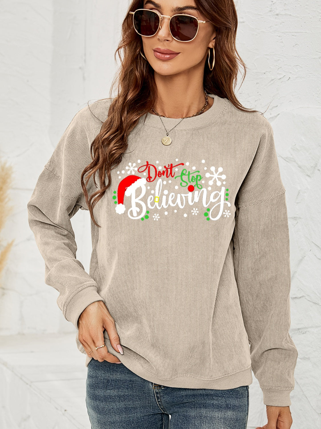 Beige corduroy crewneck sweatshirt with Christmas graphic and Santa hat detail.