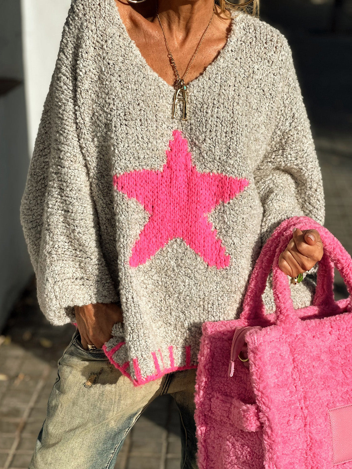 Grey knit v-neck pullover with a bold hot pink star and pink trim.