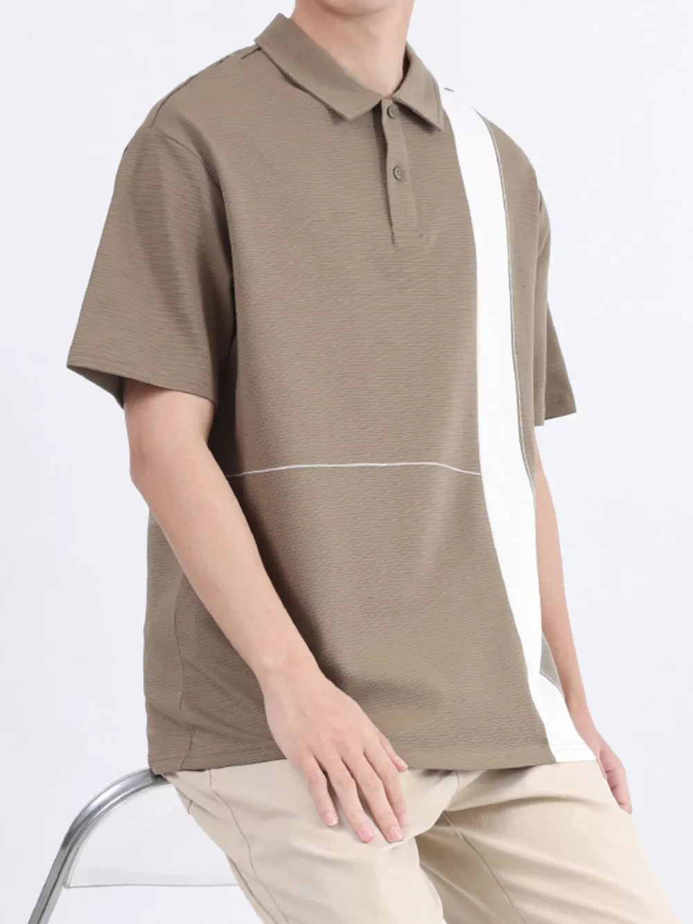 Men's camel polo shirt with white color block detail and textured fabric.