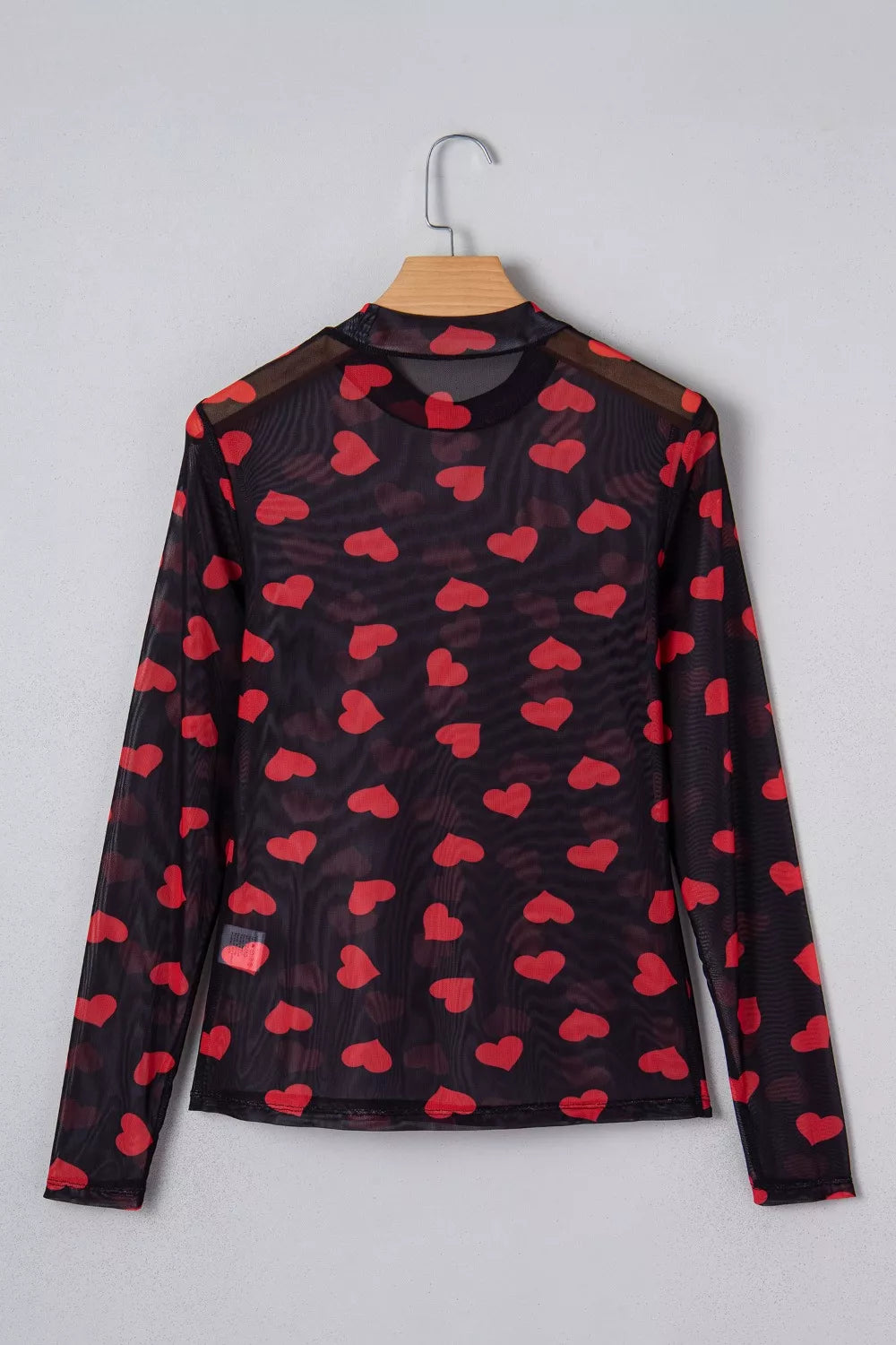 Black sheer mesh long sleeve top with all-over red heart print and mock neck.