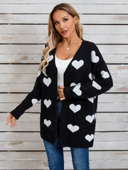 Black acrylic cardigan with white intarsia hearts, V-neck, long sleeves.