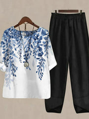 Floral print half sleeve top set in white with blue floral design and black pants.