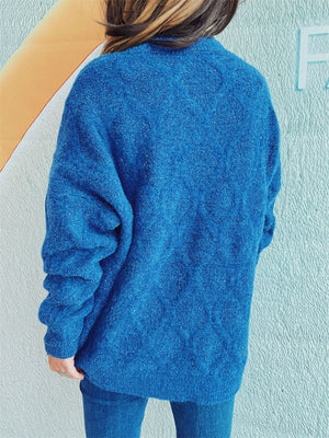 Blue sparkle knit relaxed fit sweater with textured pattern and long sleeves.