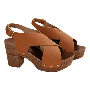 Brown crisscross high heel sandals with adjustable strap and stud details on a wood-grain block heel.
