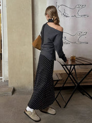Black polka dot maxi skirt with a grey one-shoulder top styled with a scarf.