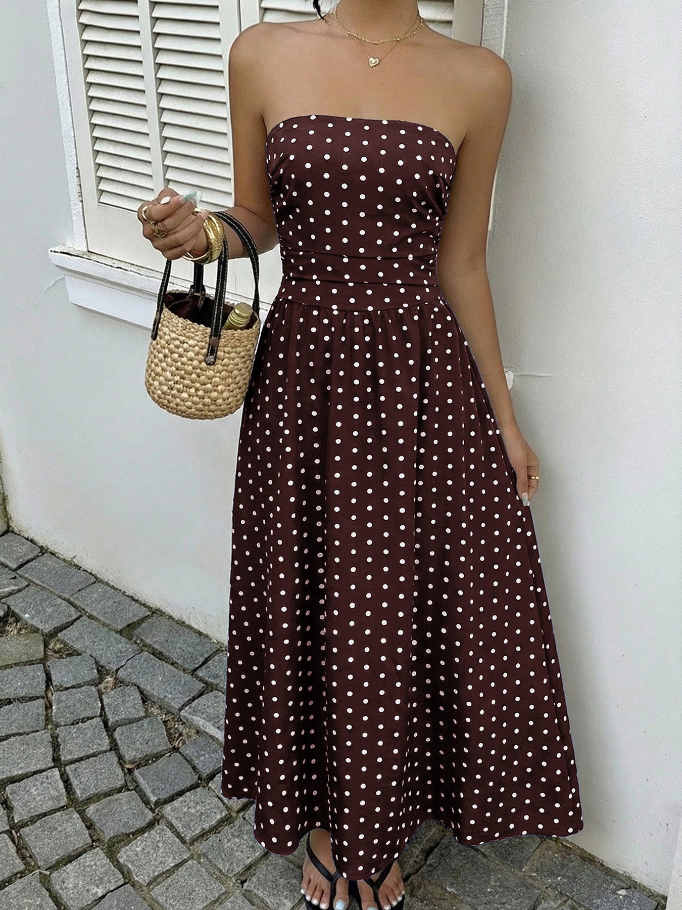 Brown polka dot strapless A-line maxi dress with a cinched waist.