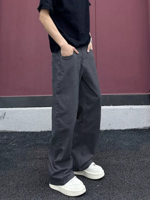 Men's grey wide-leg sweatpants with pockets, styled casually.