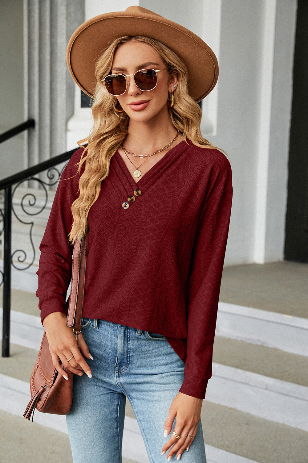 Burgundy textured henley v-neck top with button detail and long sleeves.