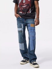 Men's relaxed fit denim jeans with distinctive patchwork design and distressed details.