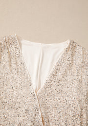 Sequin wrap bodysuit in ivory with deep V-neck and shimmering sequin detail.
