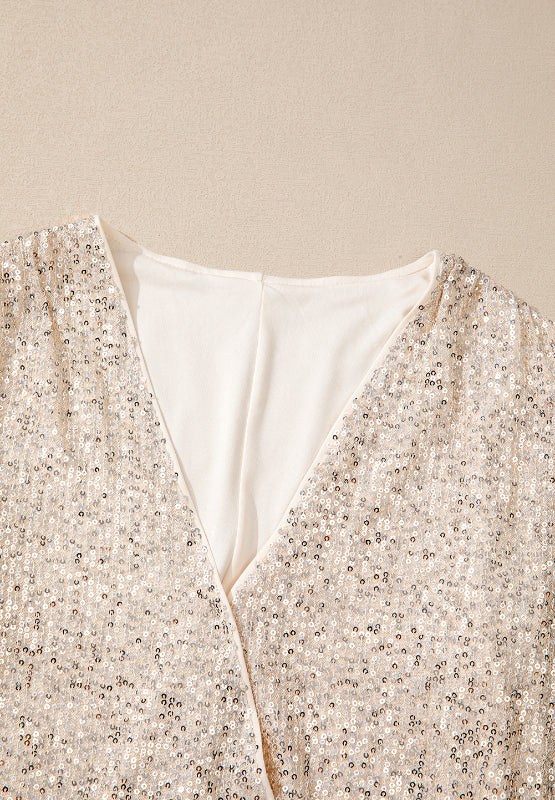 Sequin wrap bodysuit in ivory with deep V-neck and shimmering sequin detail.