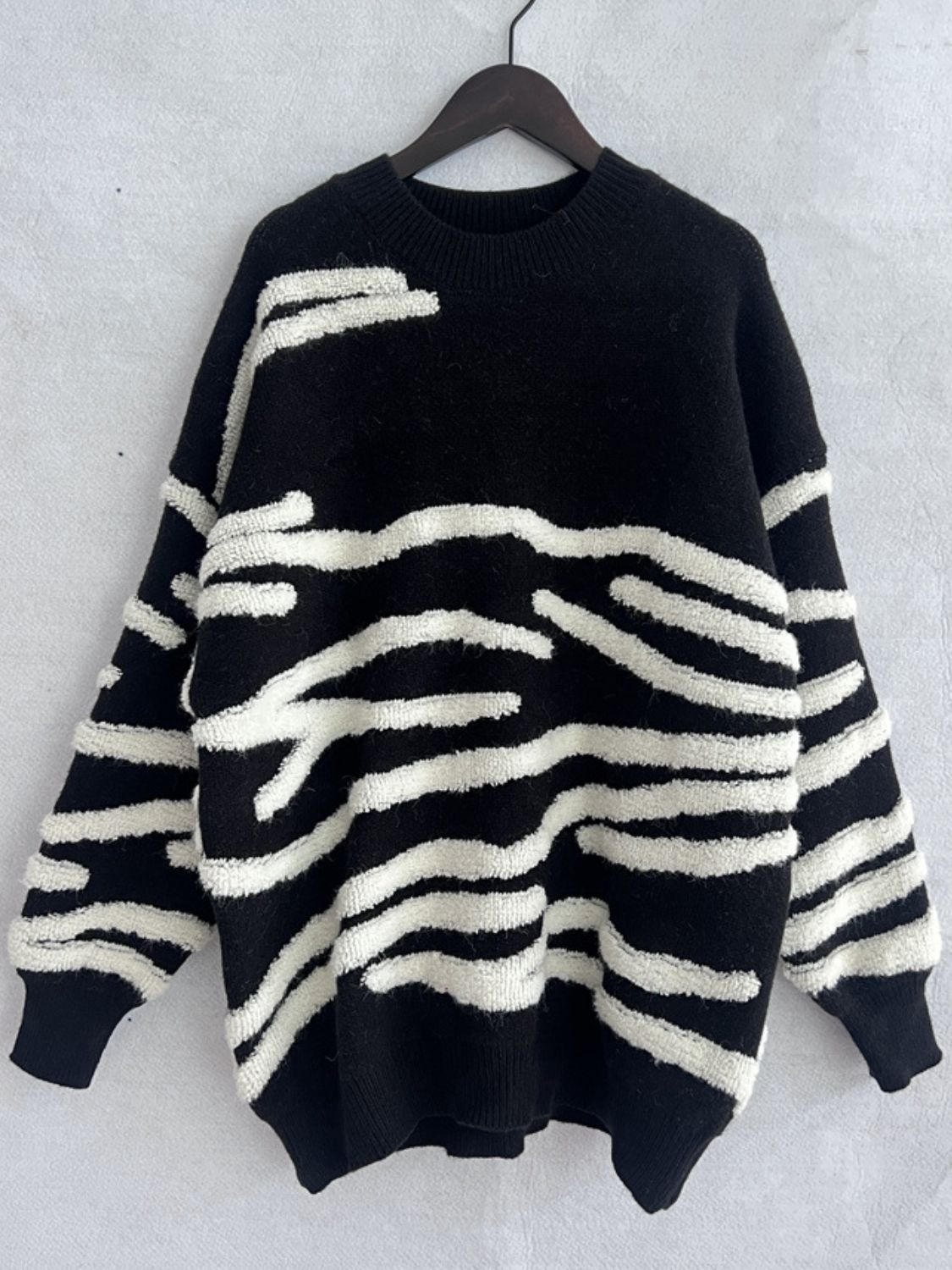 Black acrylic crewneck sweater with textured white stripe pattern