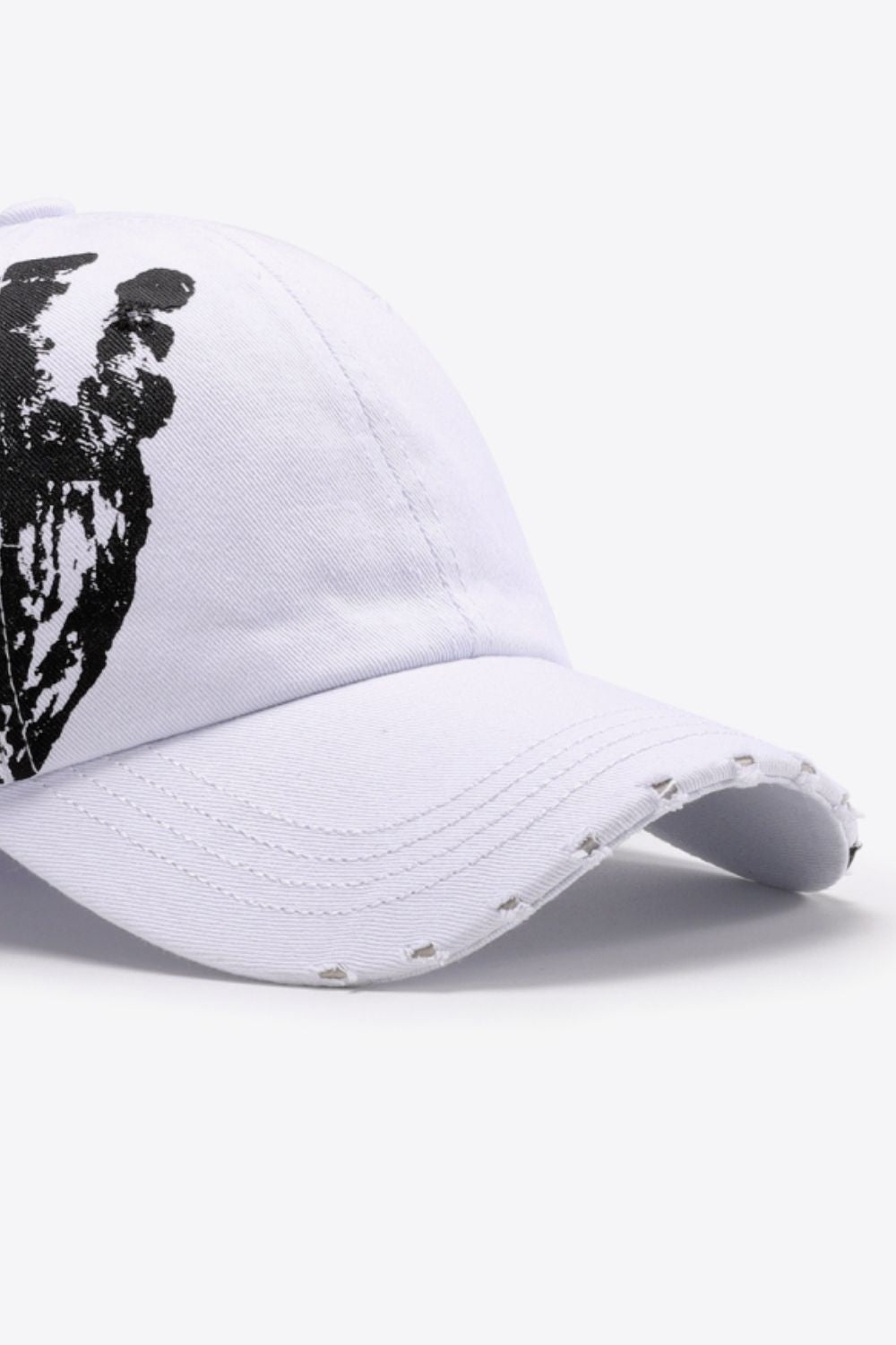 White baseball cap with black graffiti art and distressed brim.