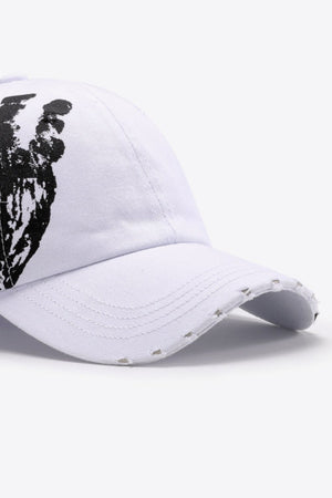 White baseball cap with black graffiti art and distressed brim.