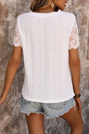 White eyelet embroidered top with scalloped lace sleeves and a textured pattern.