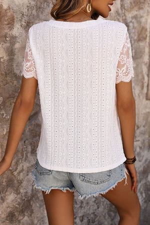 White eyelet embroidered top with scalloped lace sleeves and a textured pattern.