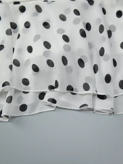 White polka dot mini dress with tiered ruffled hem detail.