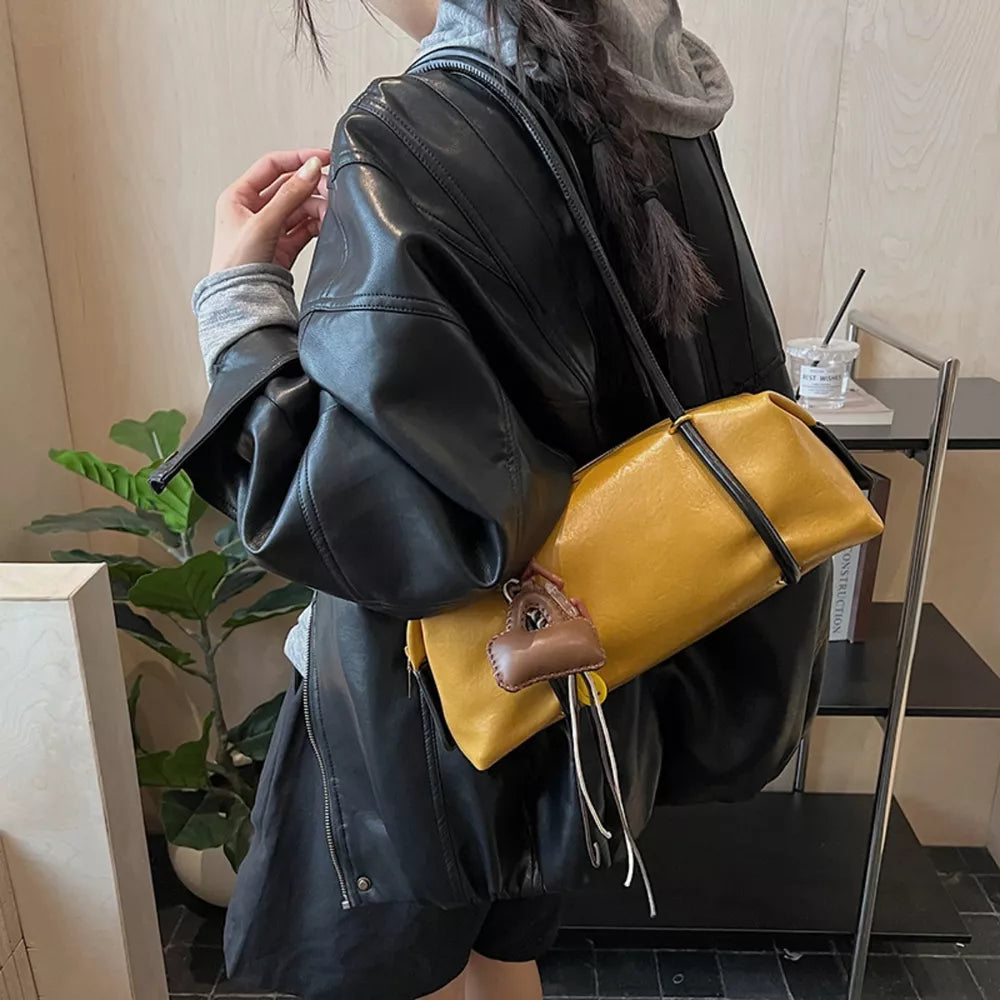 Yellow pu leather shoulder bag with charm detail and black trim