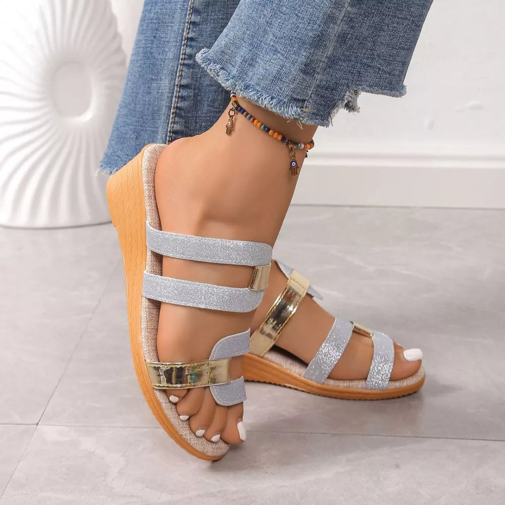 Glistening dual-strap wedge sandals in silver and gold with a cork sole.