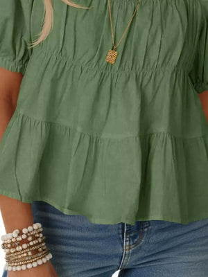 Light green maternity blouse with puff sleeves, ruffled tiers, and smocked bodice detail.