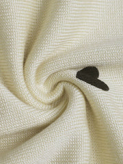 Cream acrylic sweater with scattered dark heart intarsia knit detail.