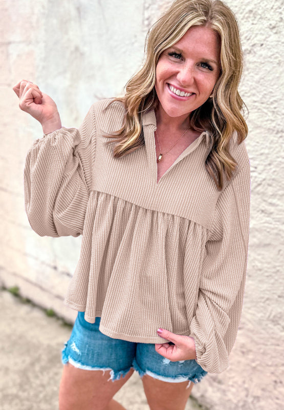 Beige textured blouse with gathered yoke, collar, and balloon sleeves.