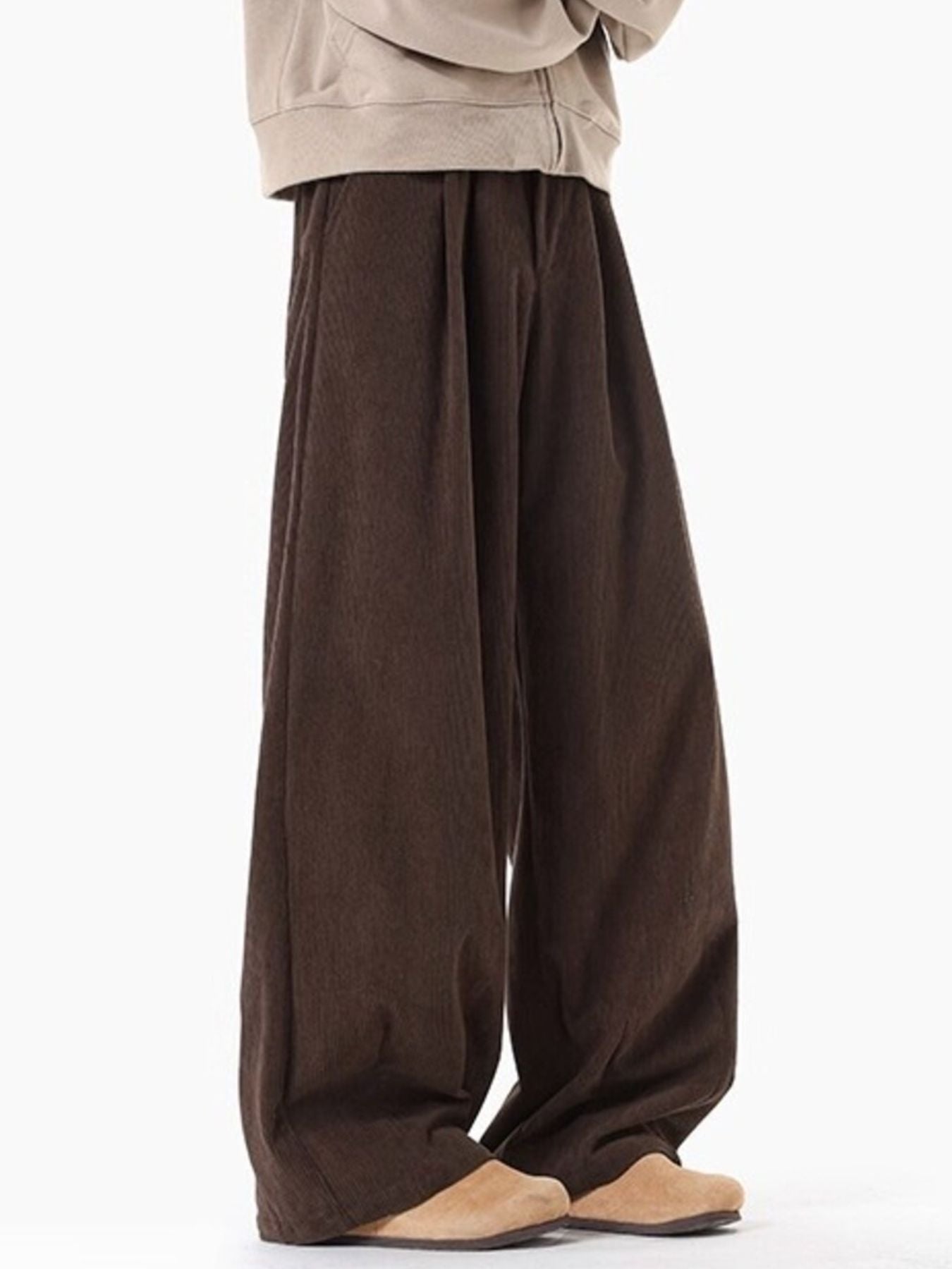 Brown pleated wide leg trousers with a relaxed fit.