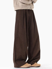 Brown pleated wide leg trousers with a relaxed fit.