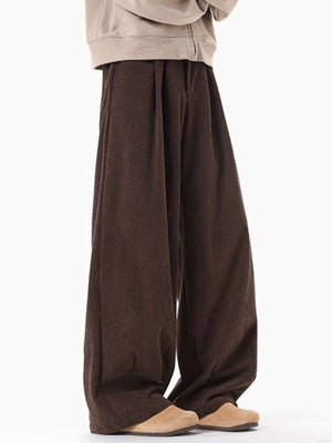 Brown pleated wide leg trousers with a relaxed fit.