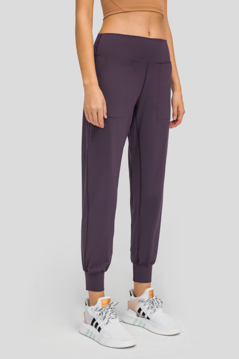 Plum purple jogger fit performance trousers with pockets and cuffed ankles.