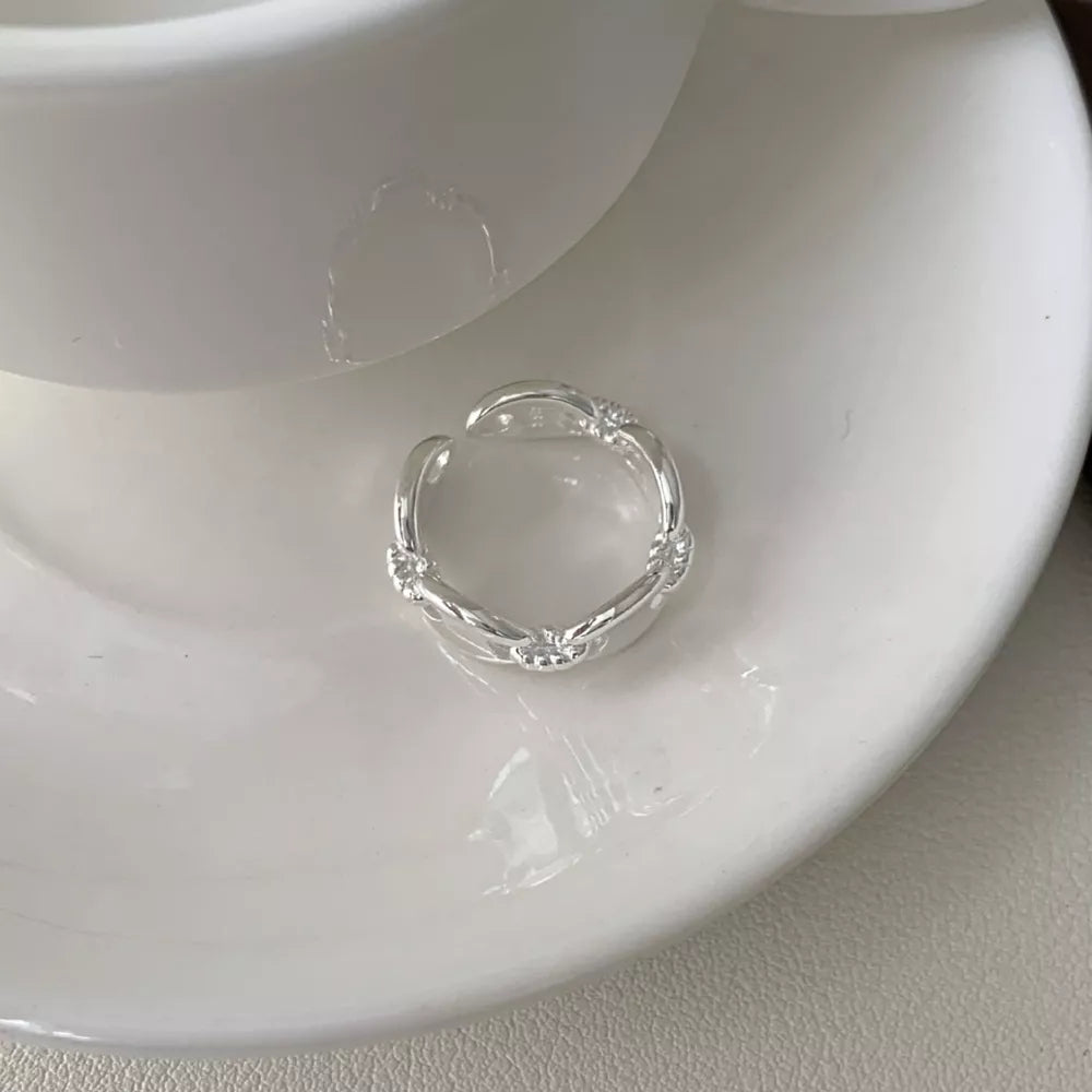 Sterling silver ring with interconnected oval links and delicate detailing.