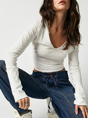 White long sleeve slouchy tee with distressed plunge neckline and raw hem details.