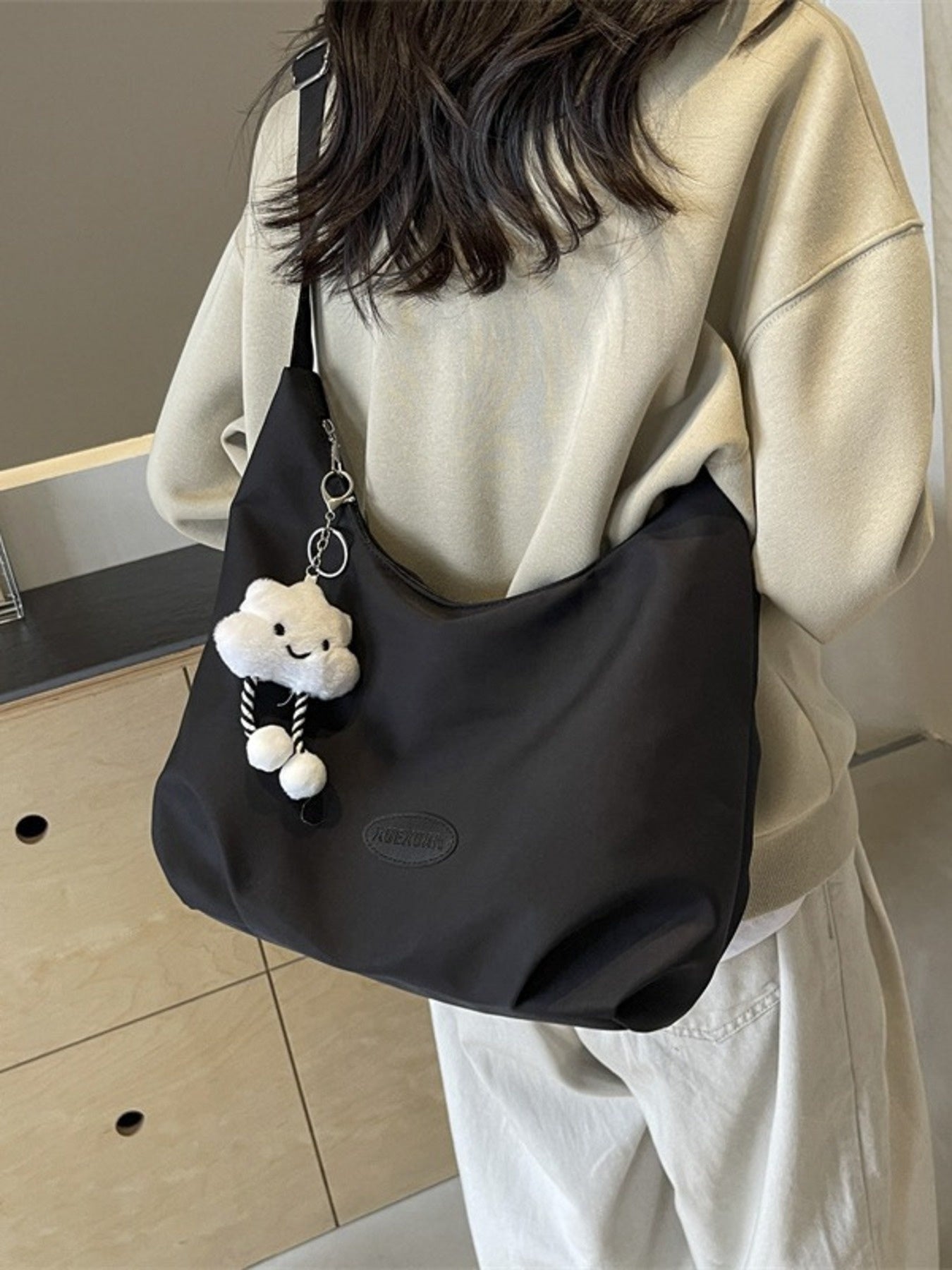 Black canvas shoulder bag with adjustable strap and cloud charm