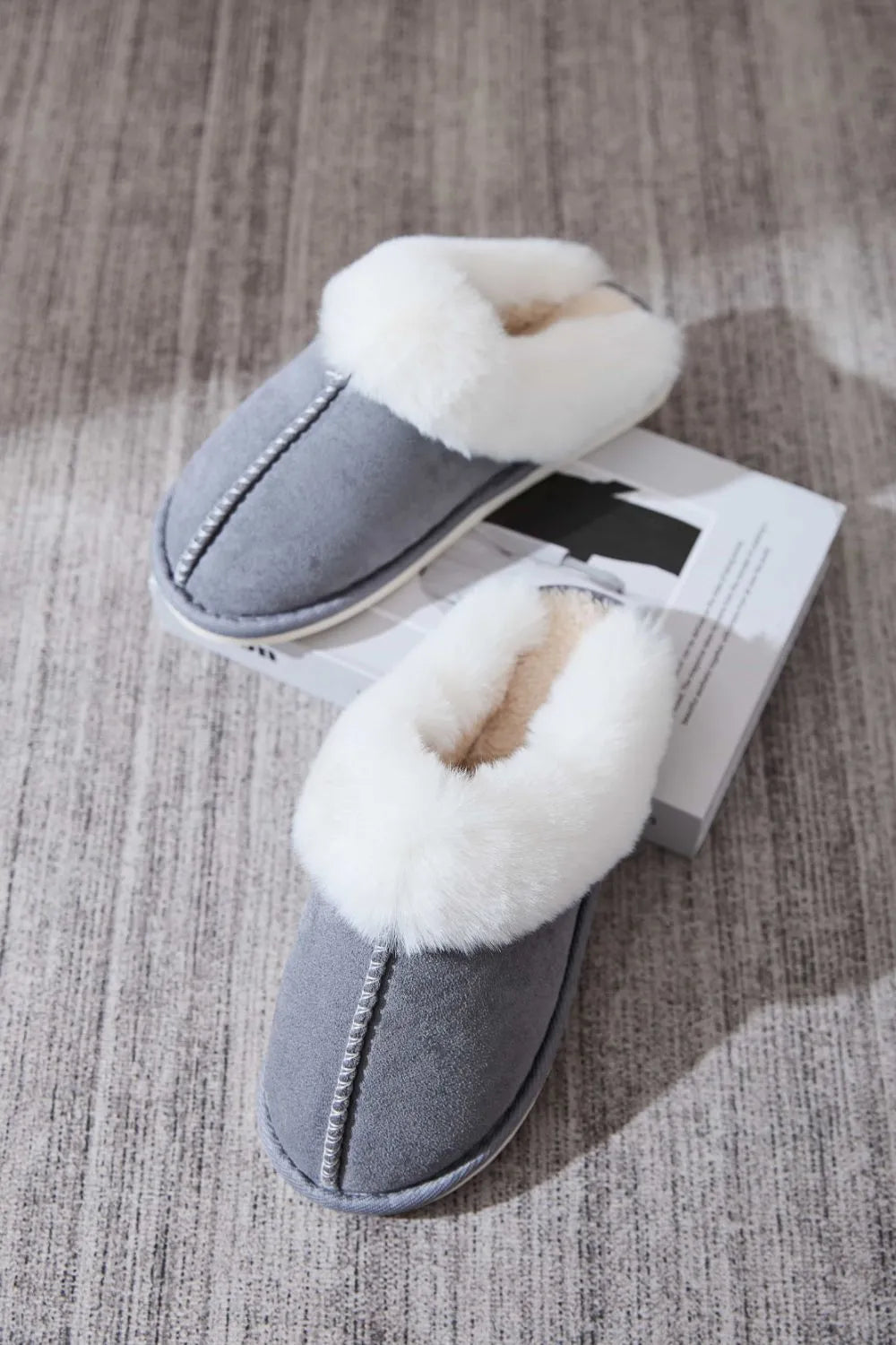 Dark gray suede house slides with white shearling trim and decorative stitching.