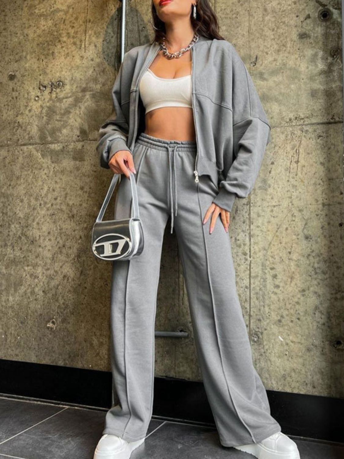 Gray zip-up jacket and wide-leg sweatpants set with drawstring waist, styled with a white crop top.