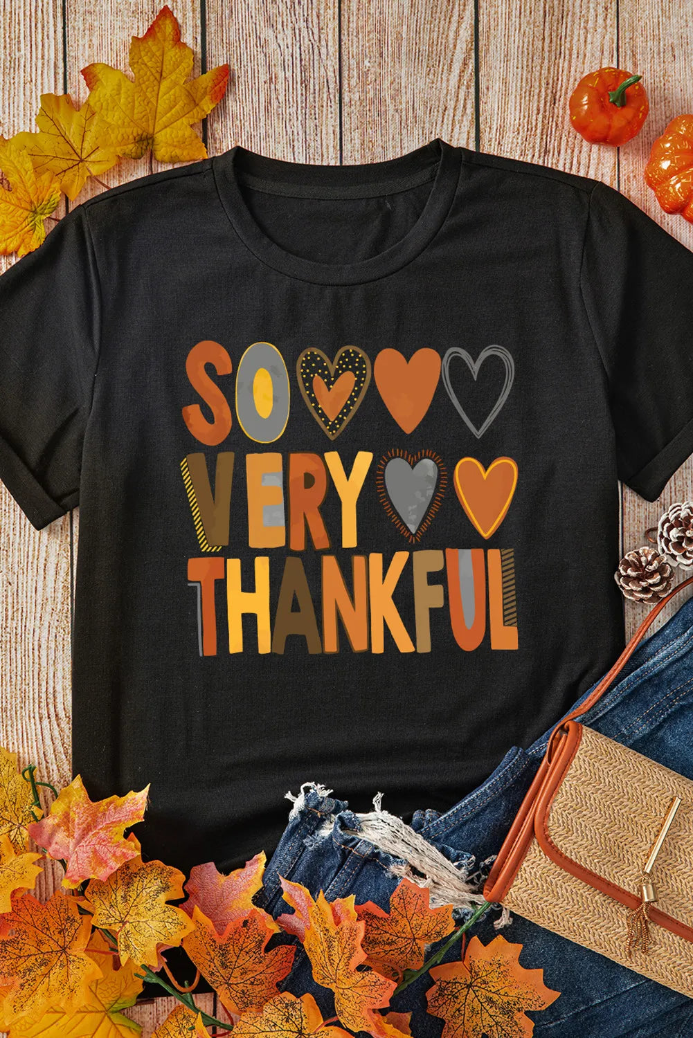 Black graphic tee with "So Very Thankful" text and heart details, autumn colors.