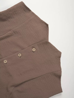 Taupe cropped vest with button details and wide-leg pants ensemble