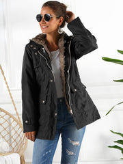 Black belted utility parka with faux fur lining and hood, featuring multiple pockets.