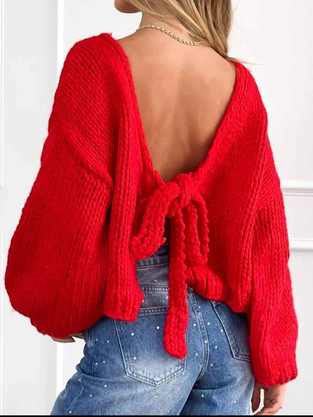 Red tie-front knit cardigan with textured detail and open back.