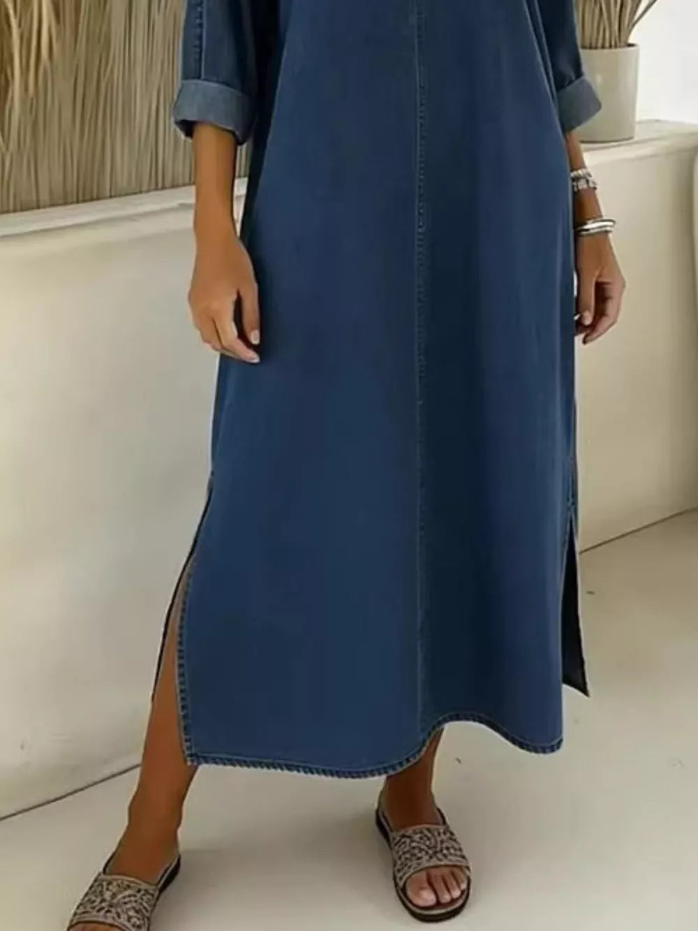 Dark blue denim midi dress with V-neck, cuffed sleeves, and high side slits.