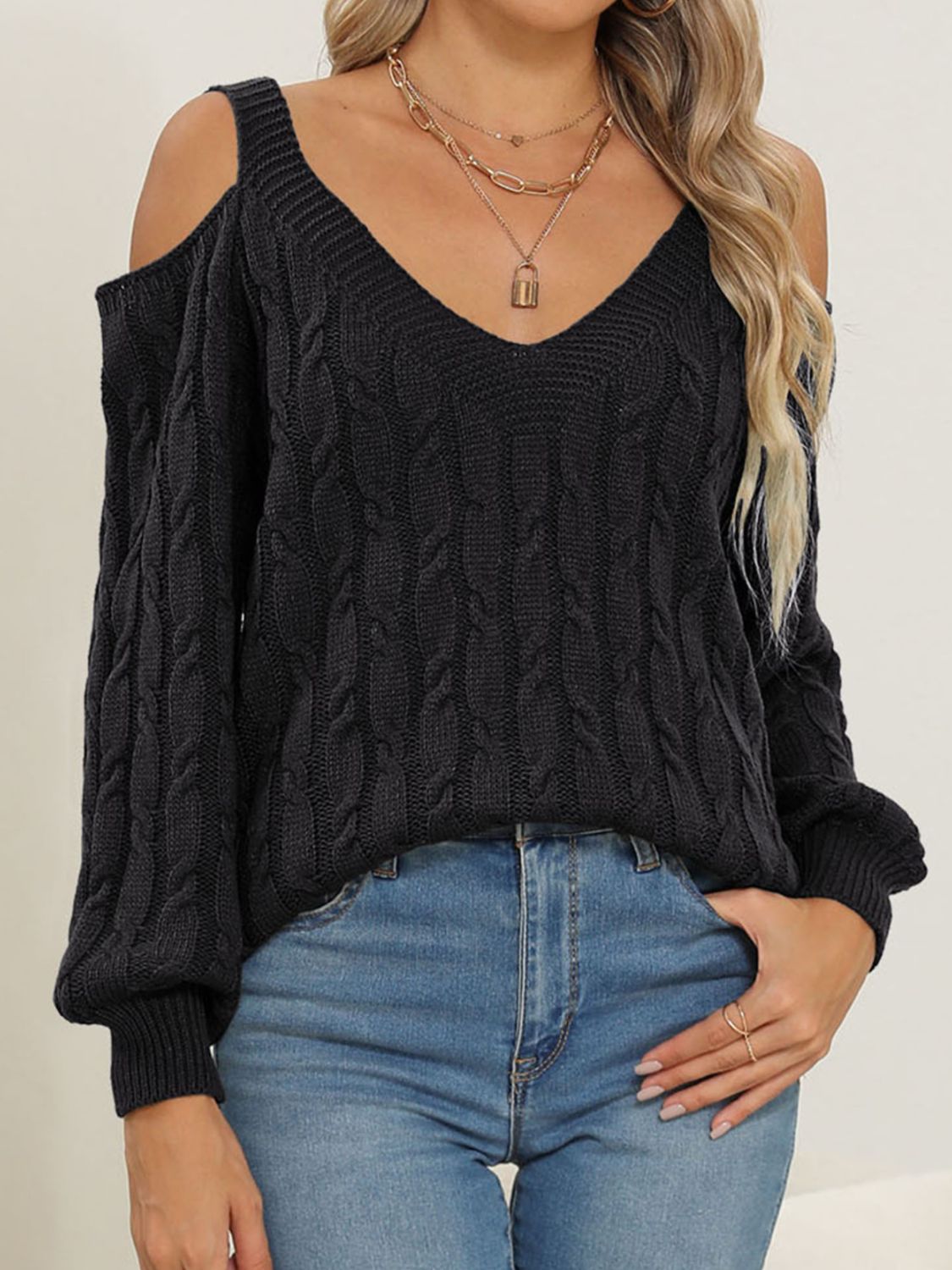 Black cable knit cold shoulder sweater with V-neck and balloon sleeves.