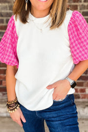 White ribbed knit blouse with pink houndstooth puff sleeves and crew neck.