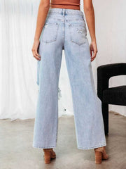 Distressed light wash wide leg denim jeans with a flare, showing ripped details.